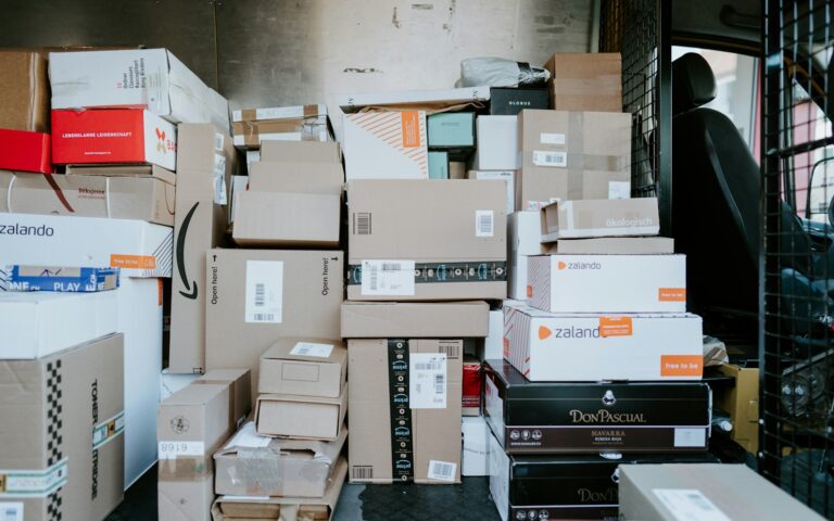 Paquetes de distintos vendedores online apilados en un almacén de envíos
