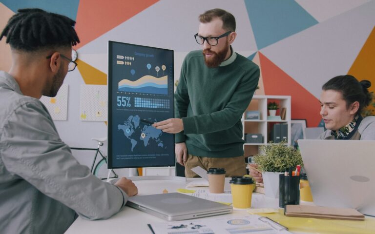 Equipo de una empresa joven analizando gráficos en una pantalla